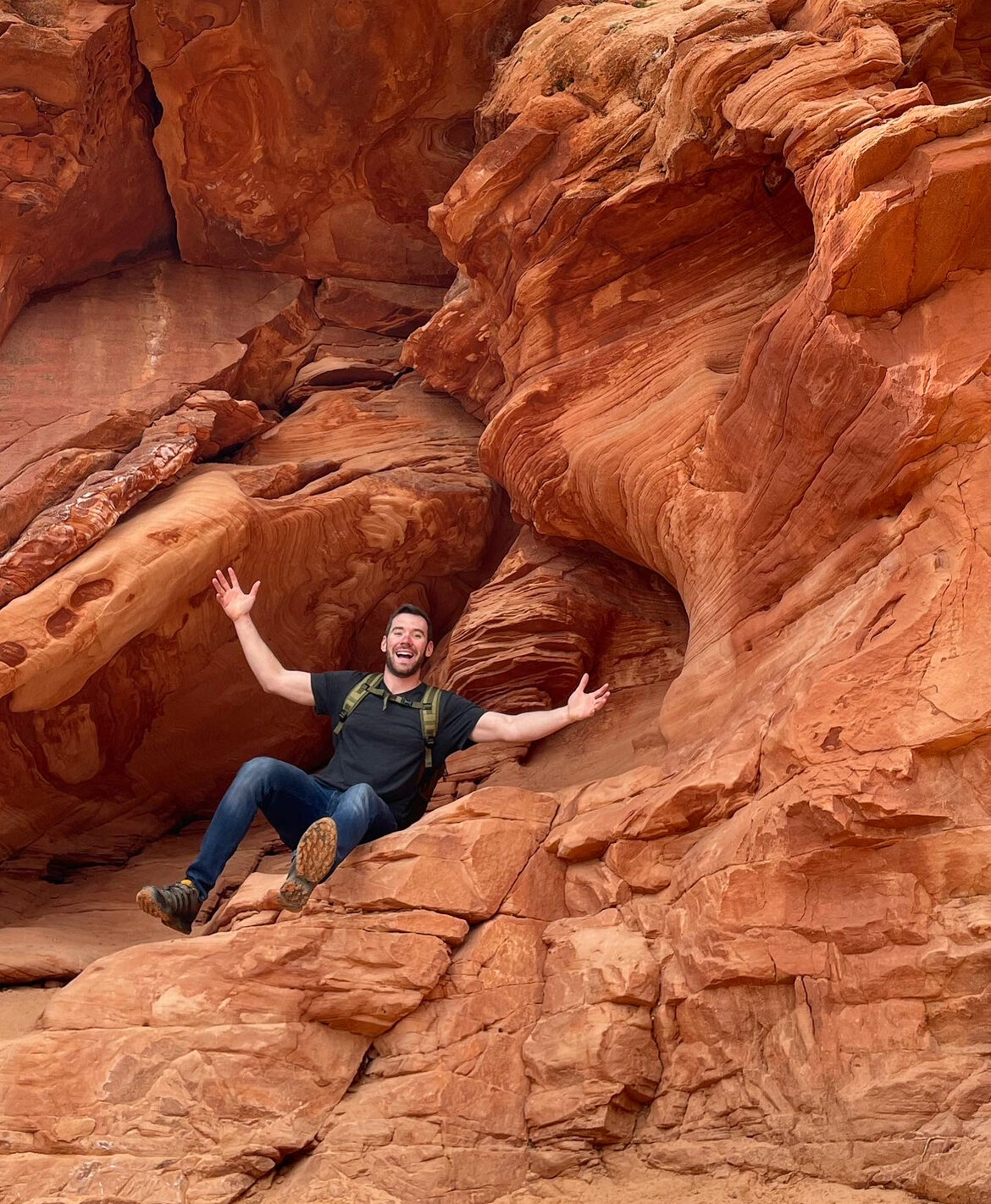 Zack with his arms wide in a red-rock canyon