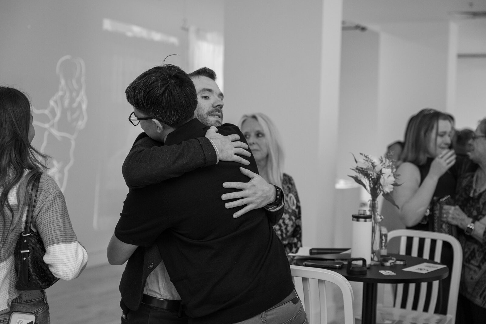 Zack embracing someone at a community gathering